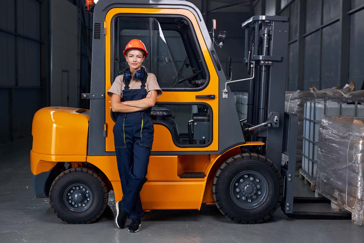 Smiling,woman,labor,worker,near,forklift,driver,in,industry,factory